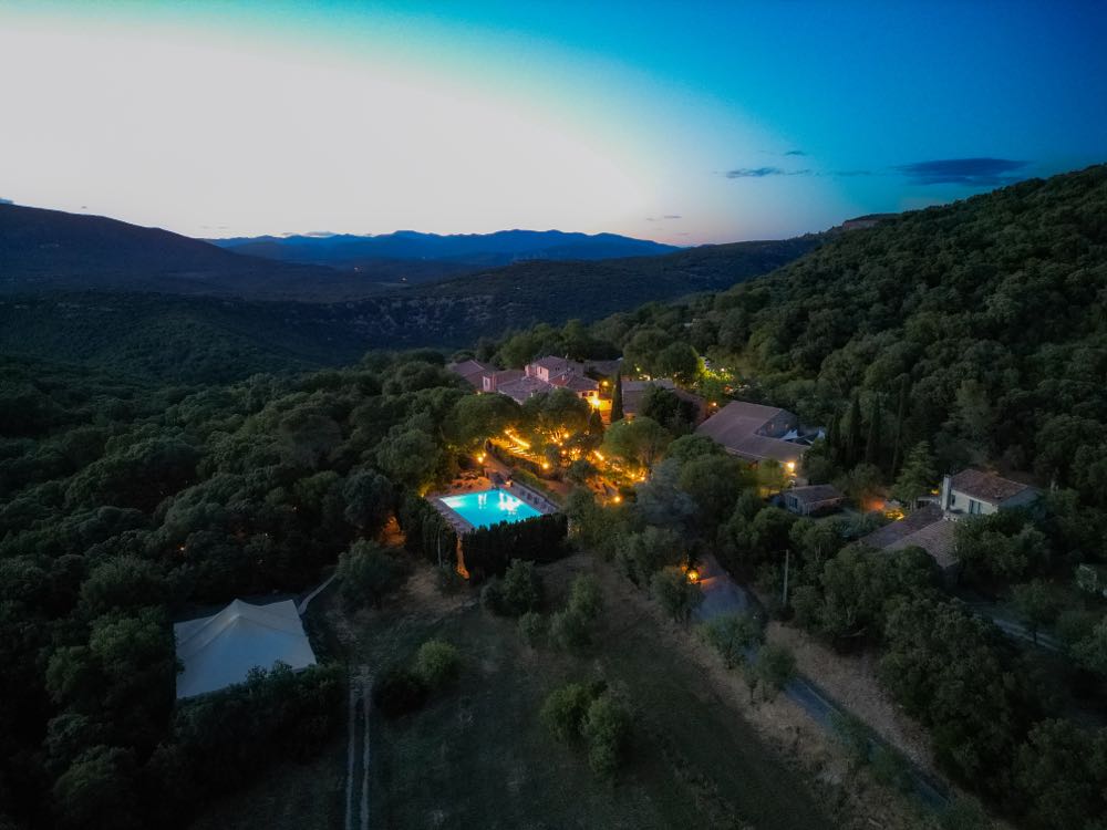 Le hameau illuminé à la tombée de la nuit, vu du ciel